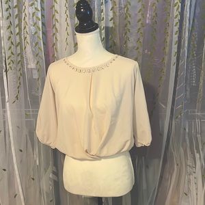 Gently used, sheer cream blouse with gem embroidery around the neckline.